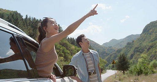 Happy young Chinese couple enjoying road trip,4K