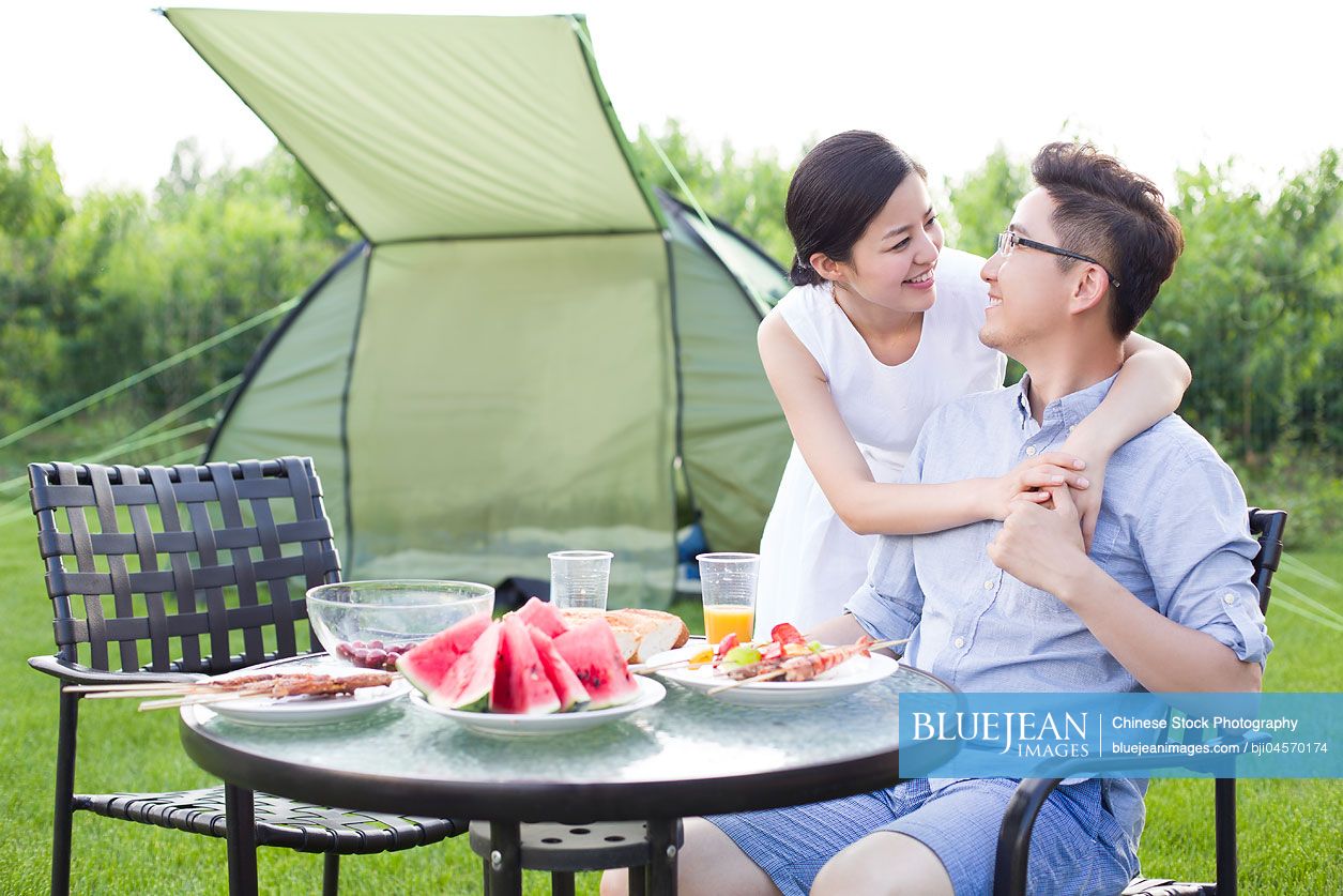 Young Chinese couple picnicking outdoors