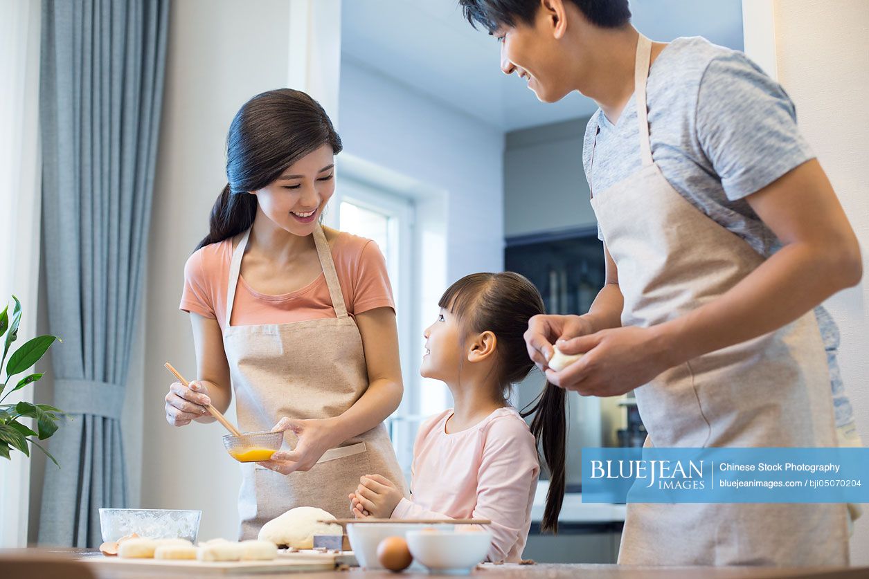 Happy young Chinese family baking together