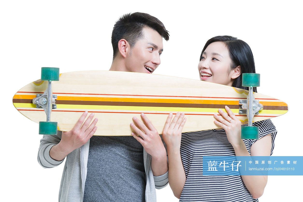 快乐的年轻情侣拿着一个滑板