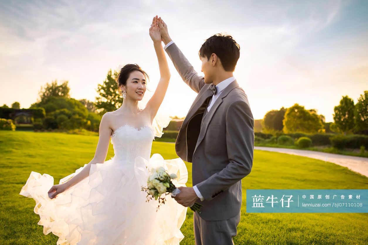 快乐的新郎新娘在草地上跳舞