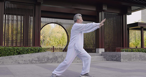 Cheerful senior Chinese man practicing Tai Chi in the park,4K