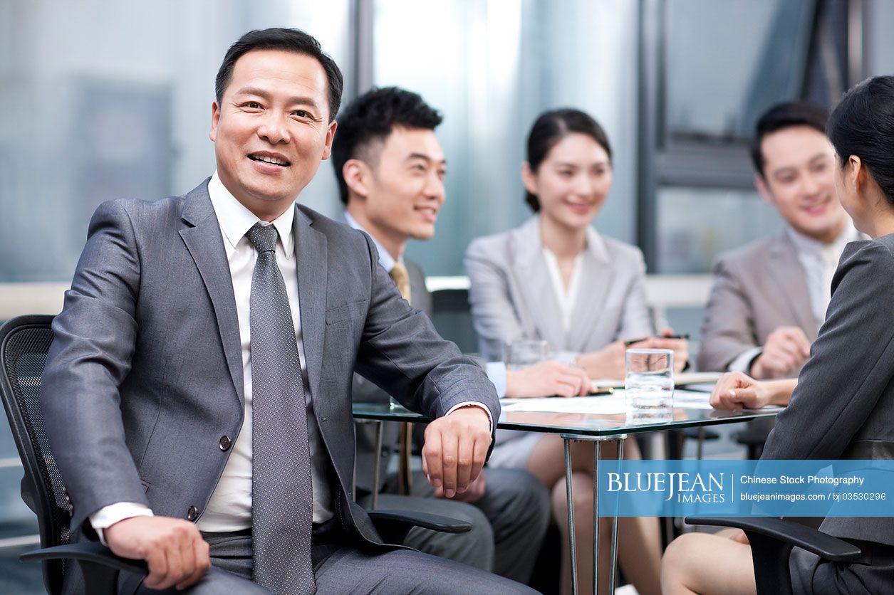 Chinese businessman with his team in background