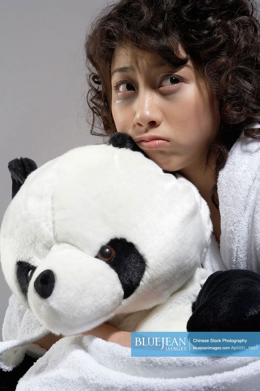 Young Chinese Woman In Bed Holding Panda Soft Toy