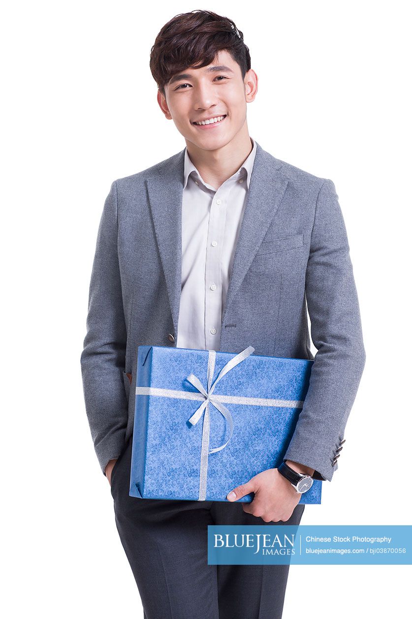 Happy young Chinese man holding a gift box