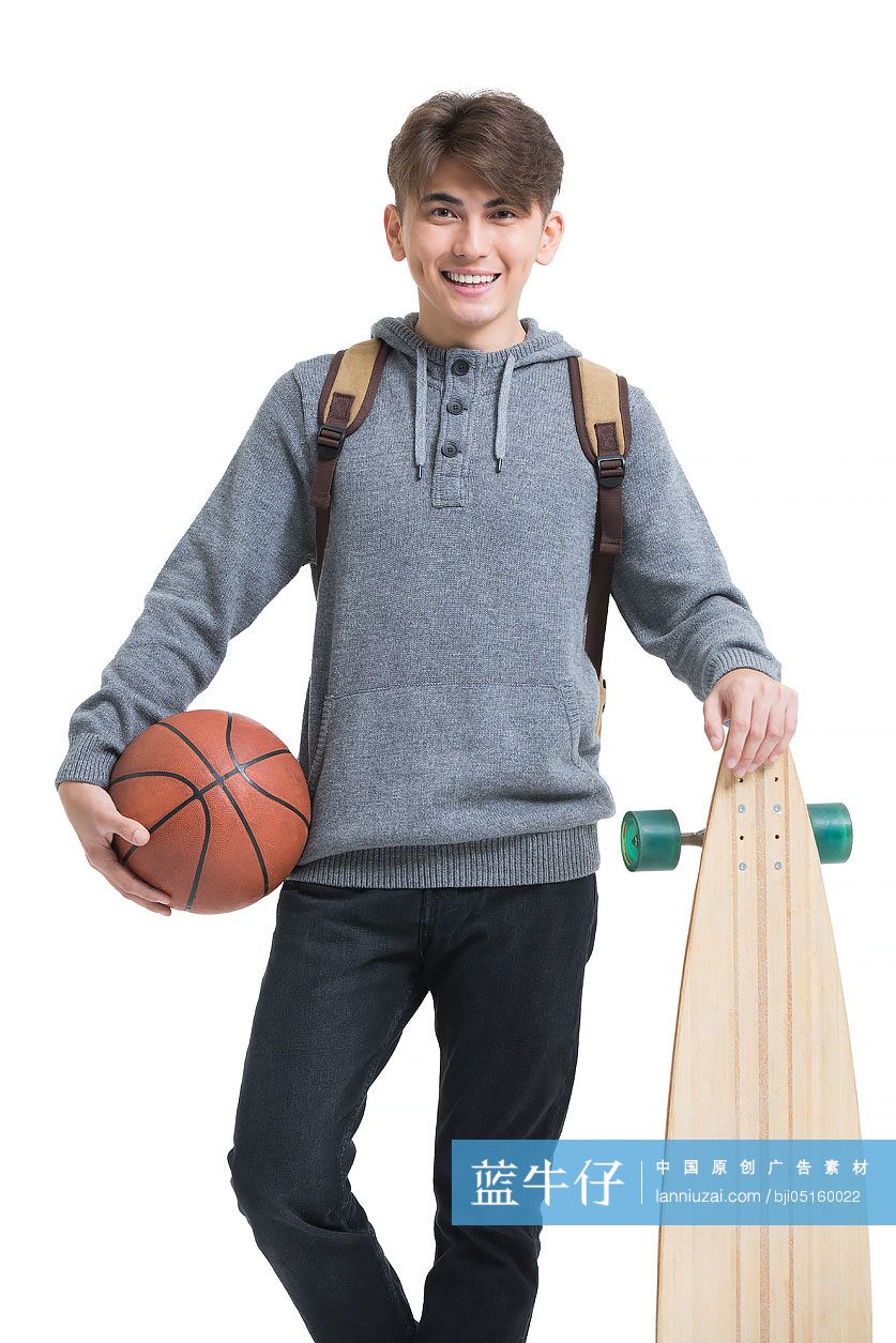 开心的男大学生拿着滑板和篮球