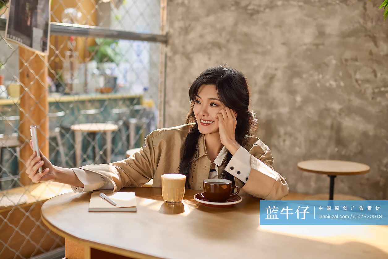 快乐年轻女性在咖啡馆自拍