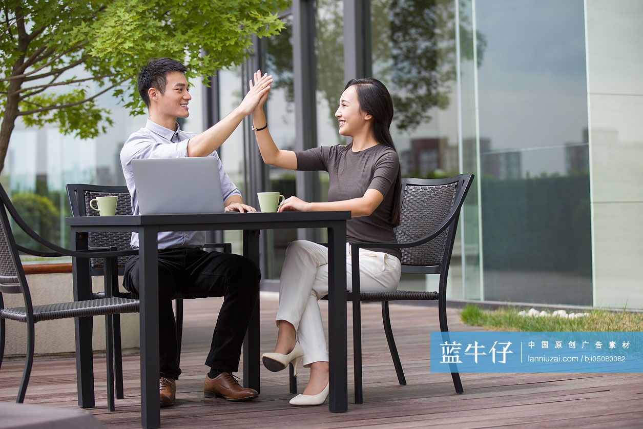 商务人士在露天咖啡馆击掌庆祝