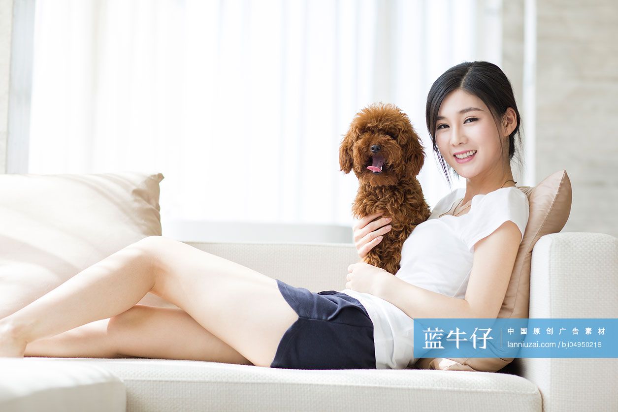 年轻女子和宠物狗在家嬉戏