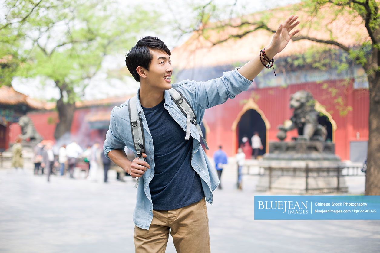 Young Chinese man waving