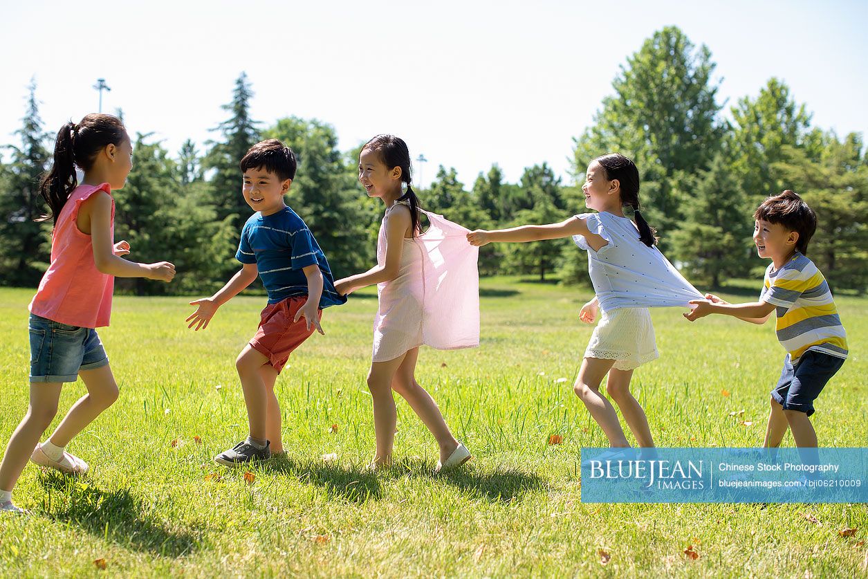 Happy Chinese children playing games on meadow