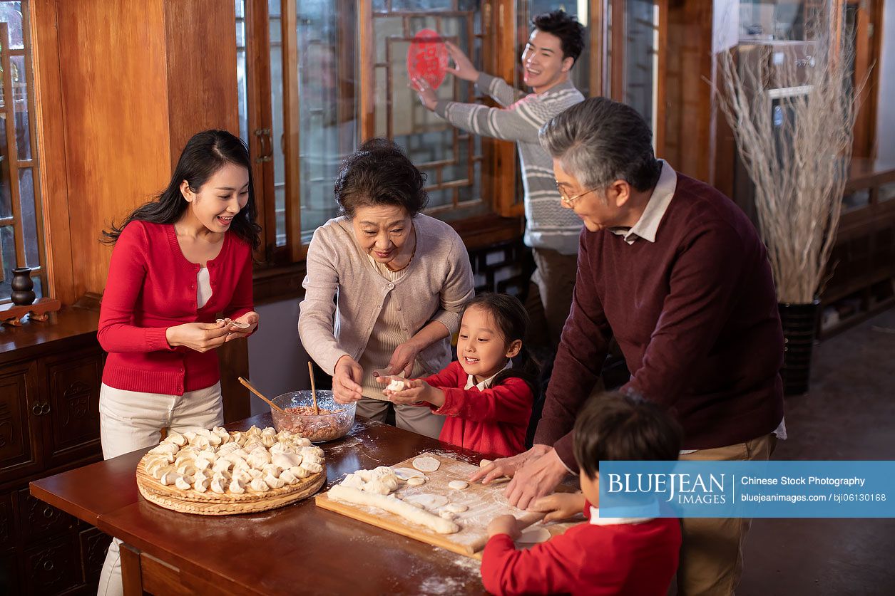 Happy Chinese family making dumplings