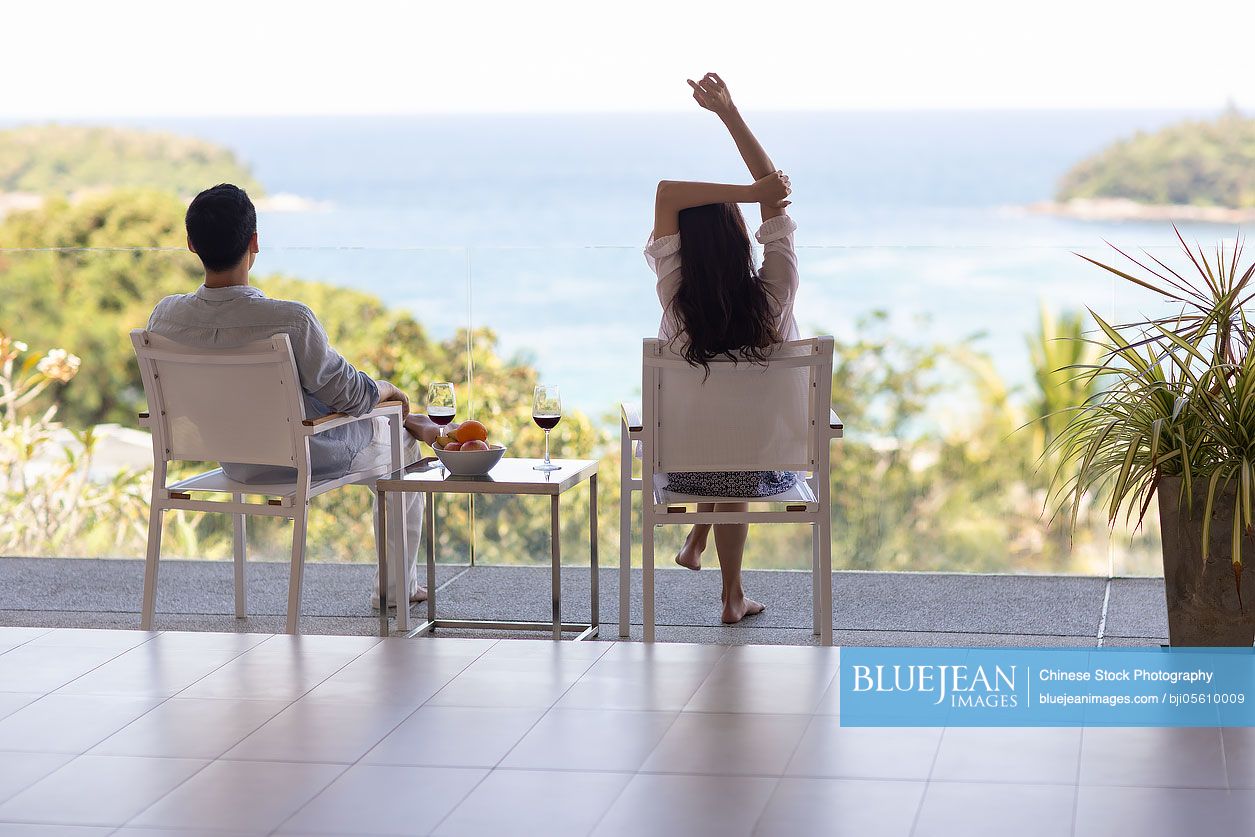 Young Chinese couple relaxing on balcony
