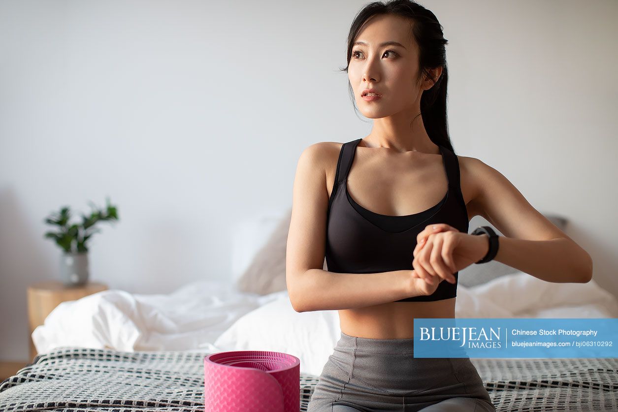 Young Chinese woman checking smart watch