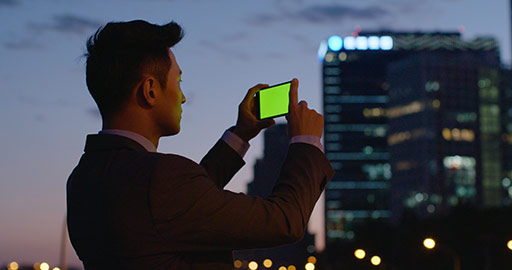 Young Chinese businessman using smartphone outdoors,4K