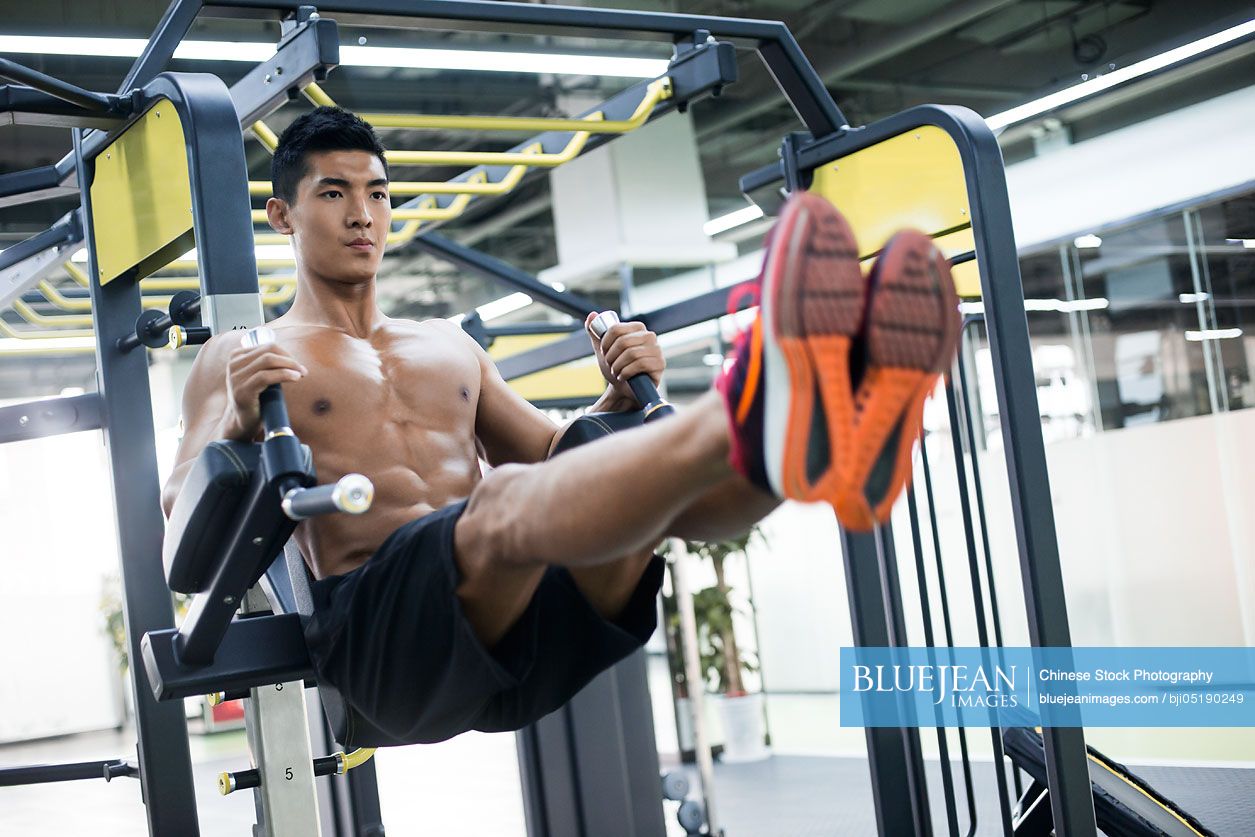 Young Chinese man exercising at gym