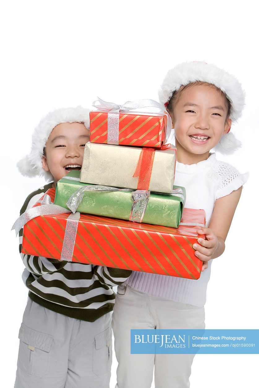Chinese Boy and girl with Santa hats holding gift Box