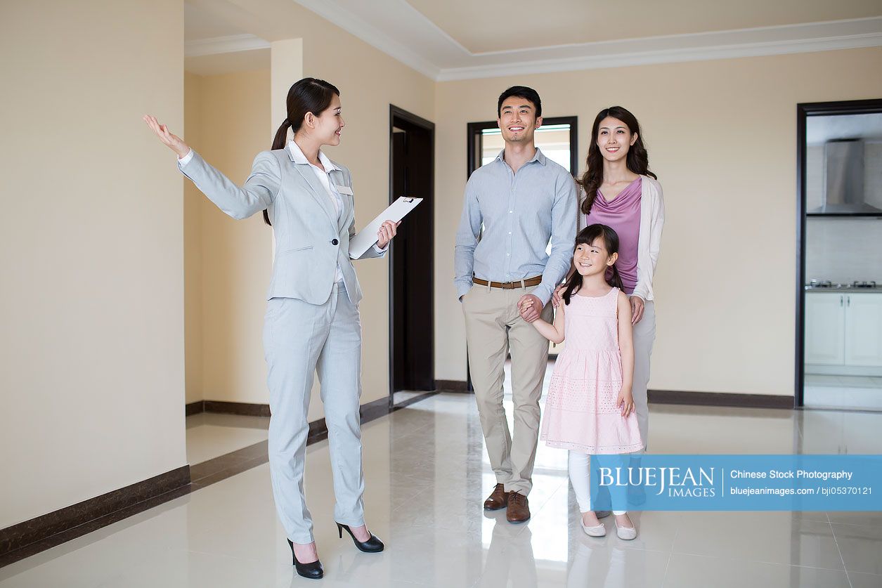 Chinese realtor showing new house to young family-High-res stock photo ...