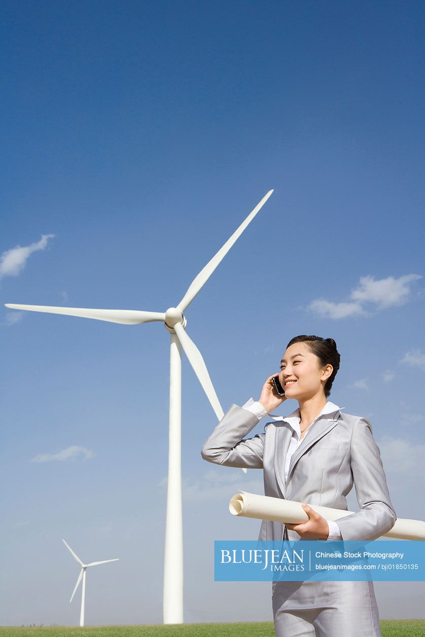 Chinese engineer in front of wind turbines
