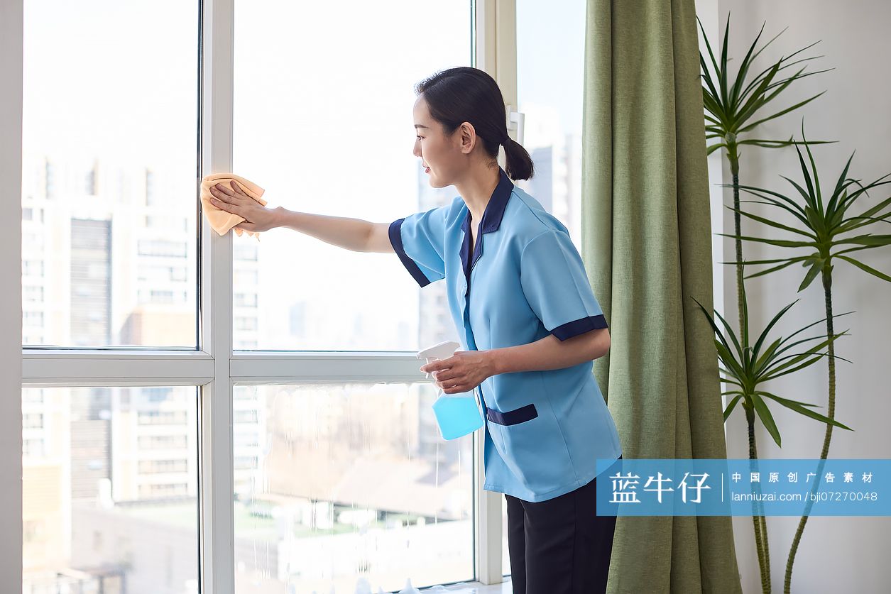 家政人员清洗窗户玻璃