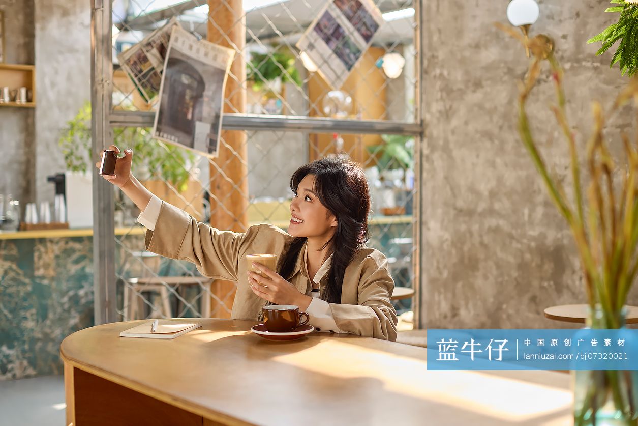快乐年轻女性在咖啡馆自拍