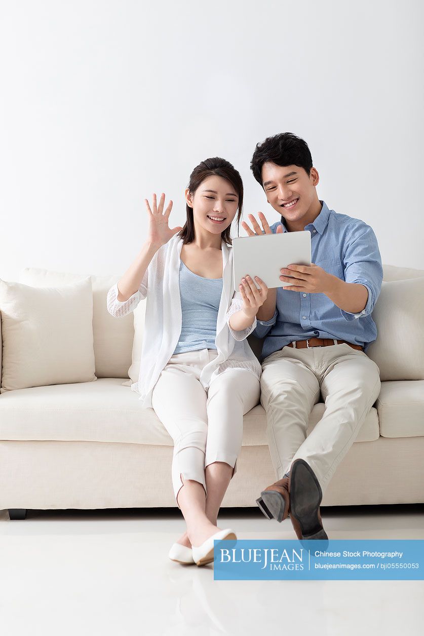 Cheerful young couple using digital tablet