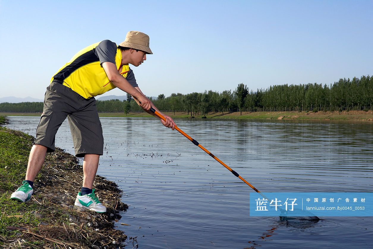 年轻男子在河边捕鱼