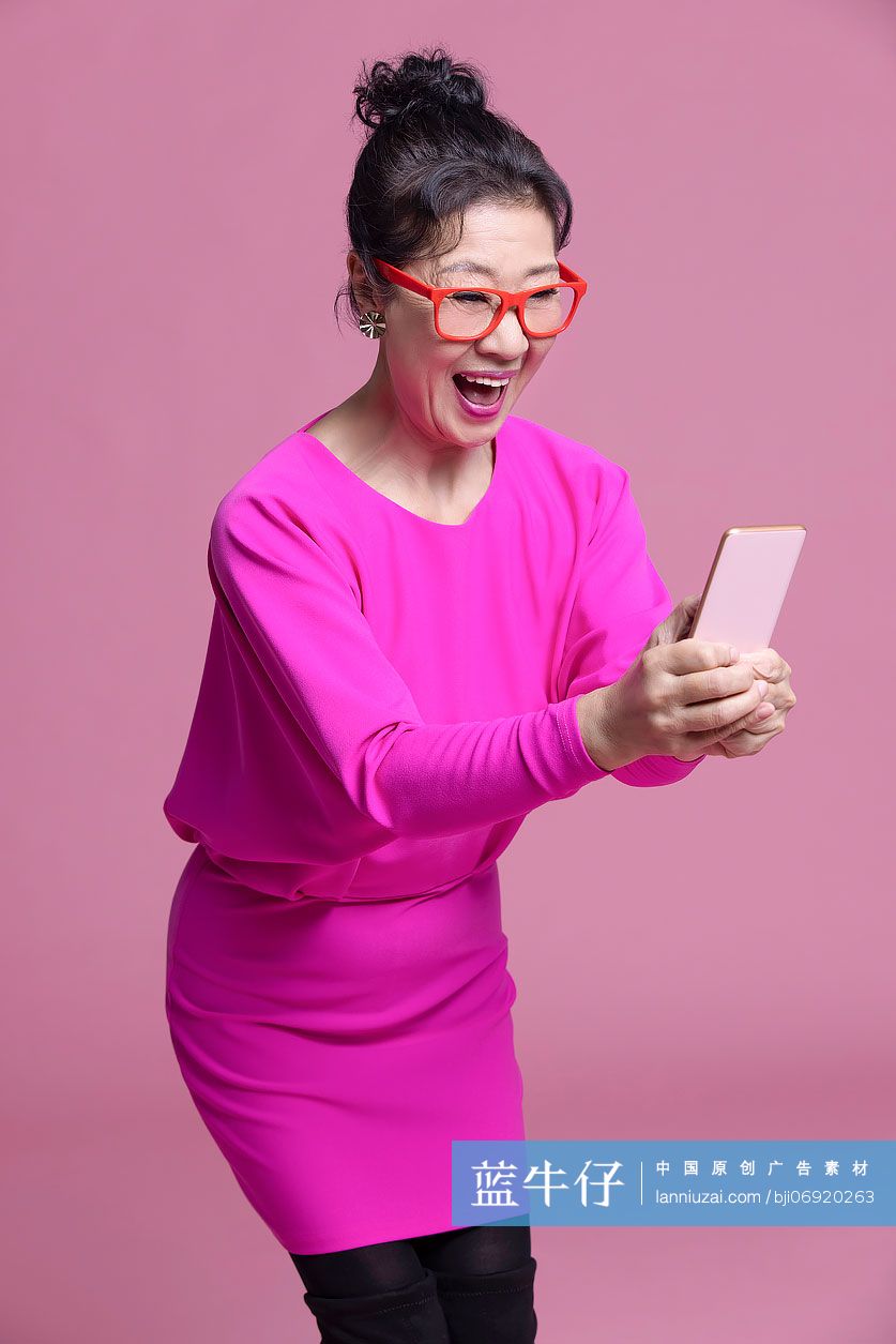 兴奋的老年女子看着手机