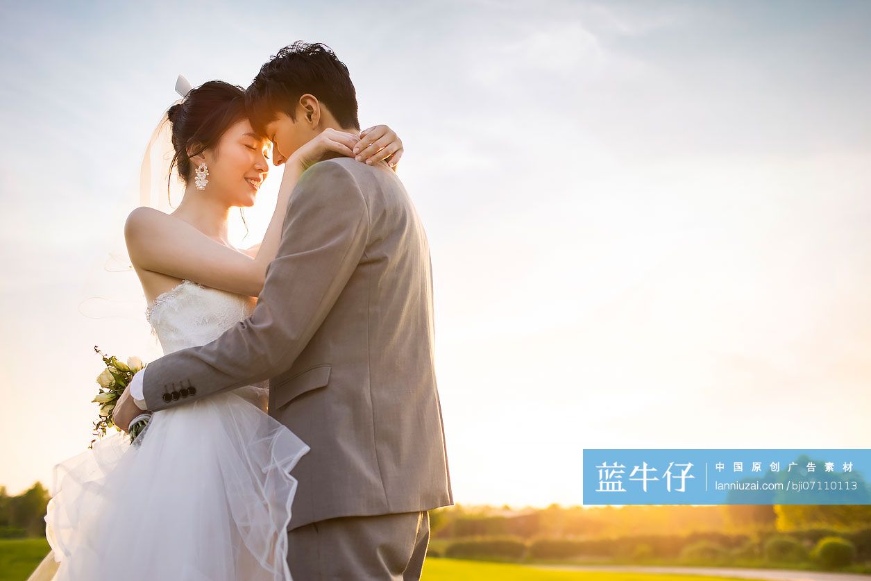 快乐的新郎新娘站在草地上