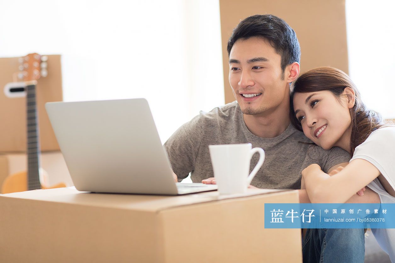 年轻夫妇在新房里使用笔记本电脑-蓝牛仔影像-中国原创广告影像素材