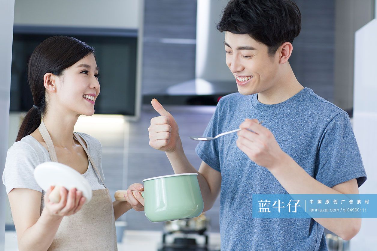 快乐的年轻夫妇在厨房做饭