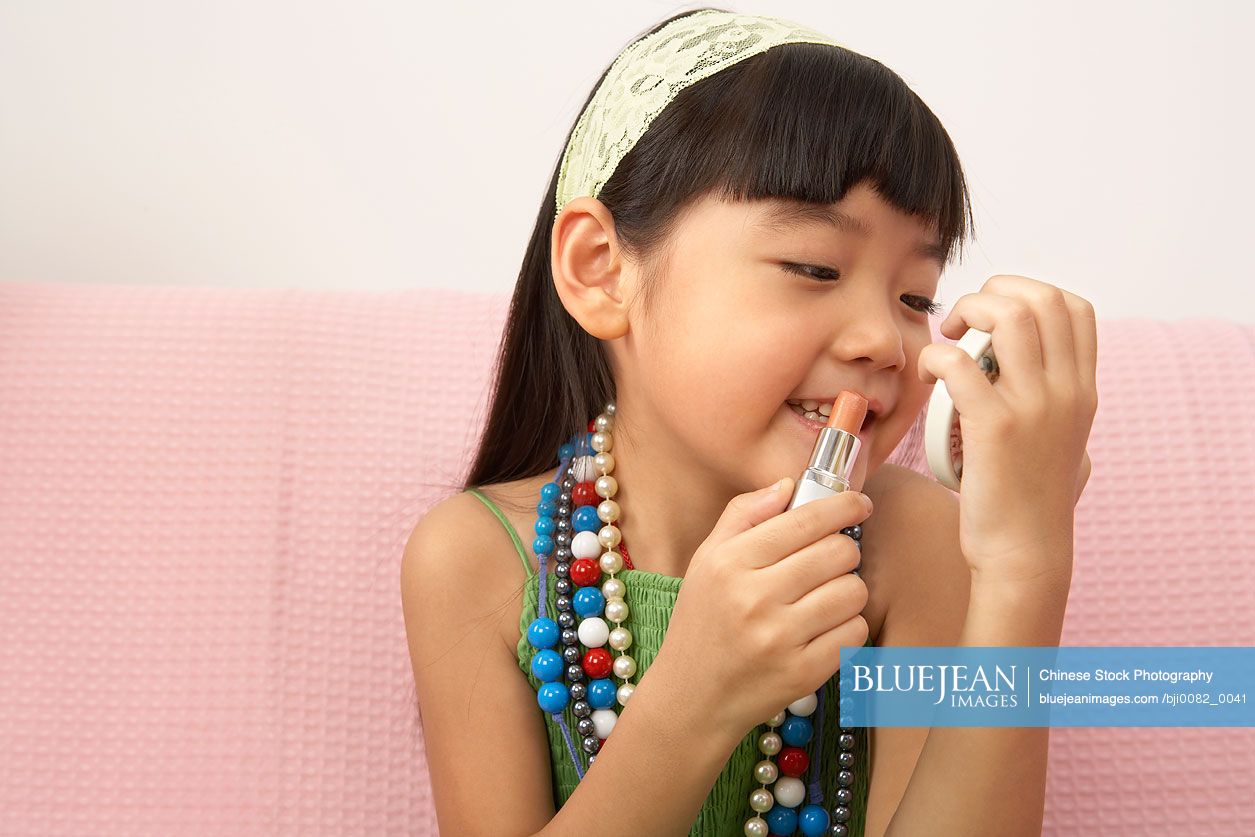 Chinese girl putting on lipstick