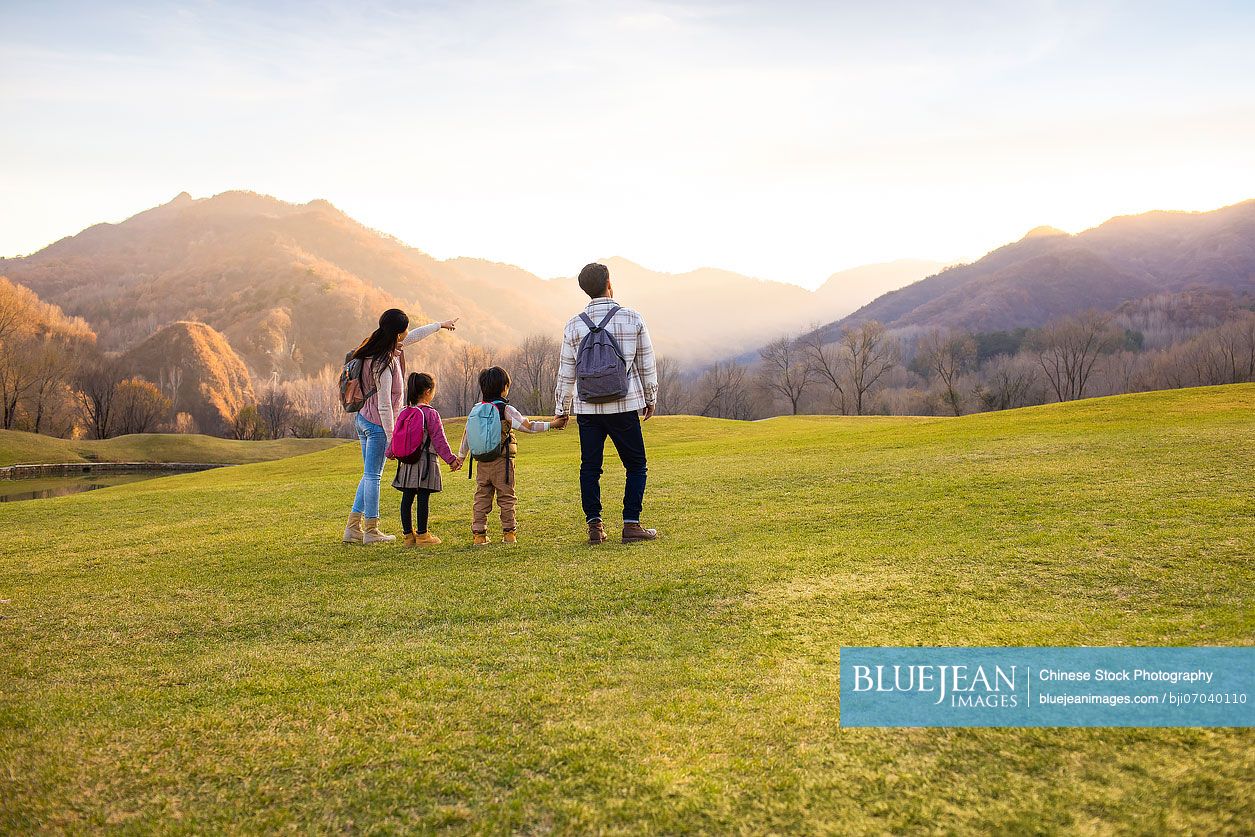 Cheerful young Chinese family enjoying the beautiful natural scenery