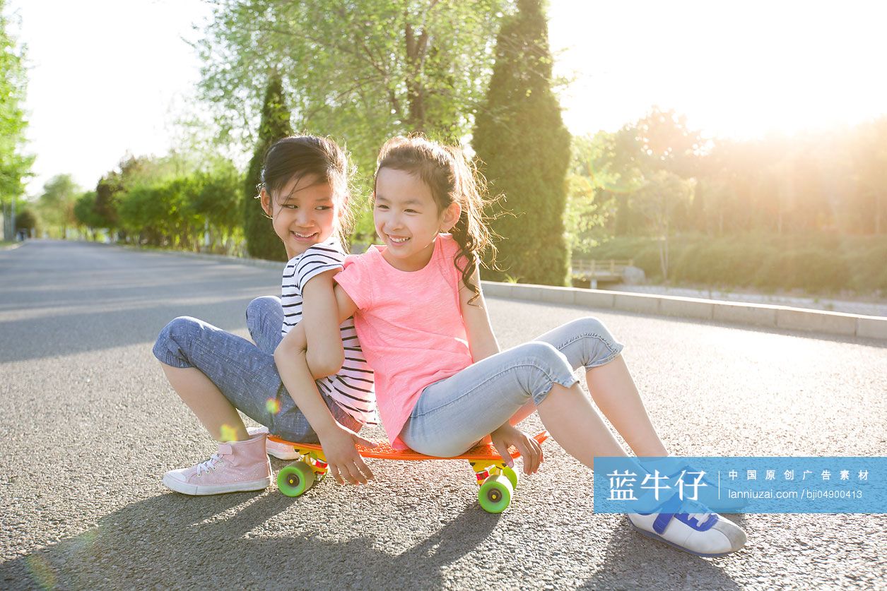 快乐的小女孩坐在滑板上