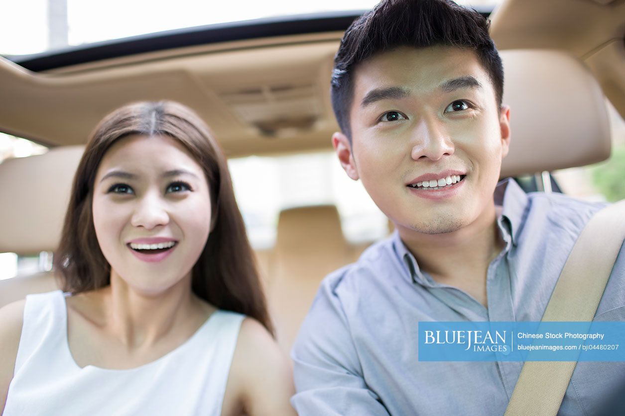 Happy young Chinese couple in a car
