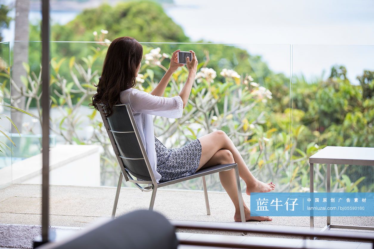 快乐的年轻女子在阳台上拍照