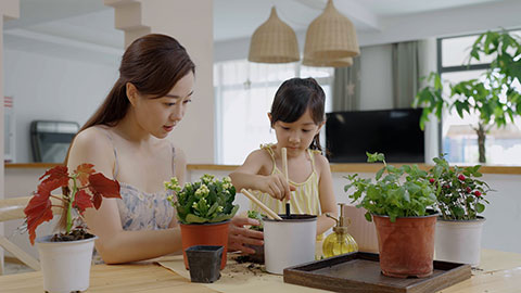 Mum and daughter enjoy potting plants together at home