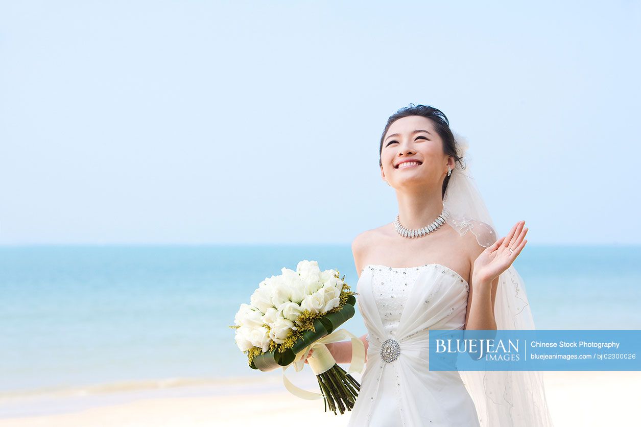 Happy Chinese bride on the beach