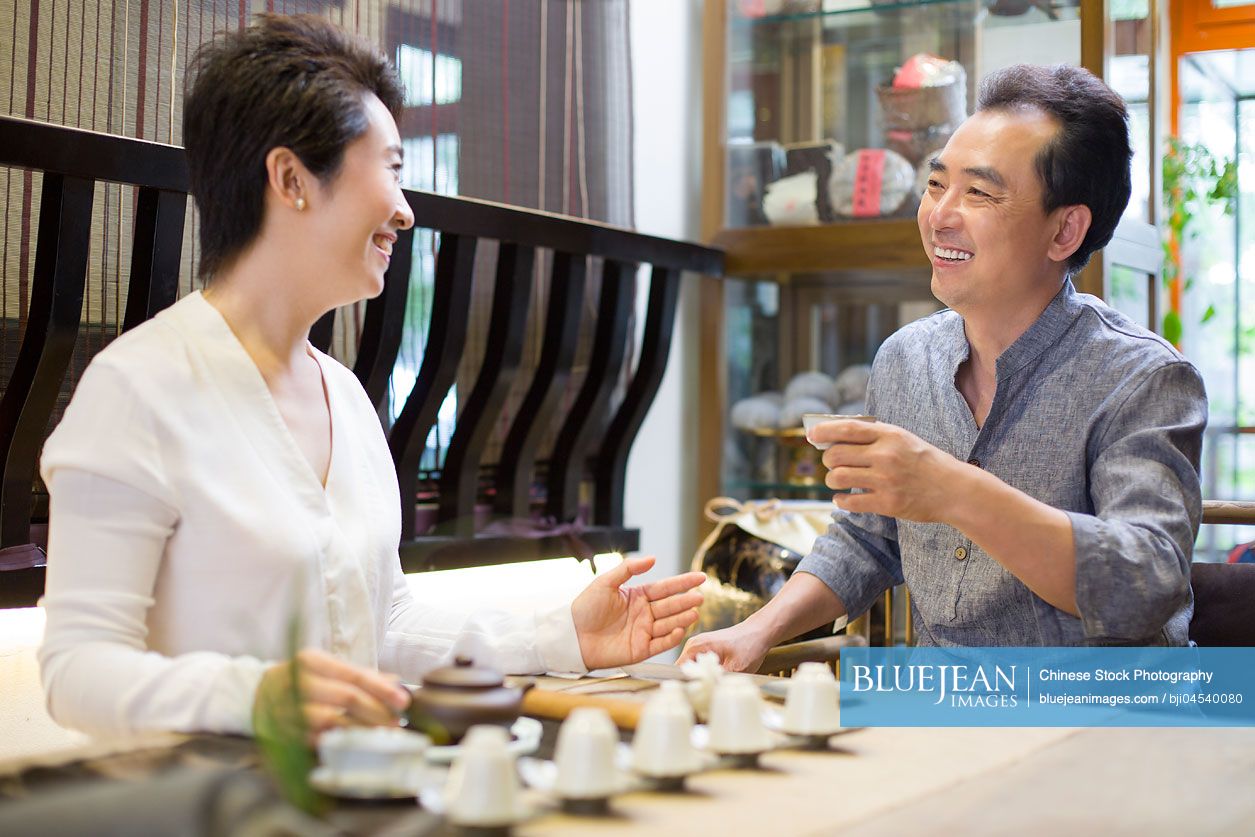 Chinese friends drinking tea and talking in tea room