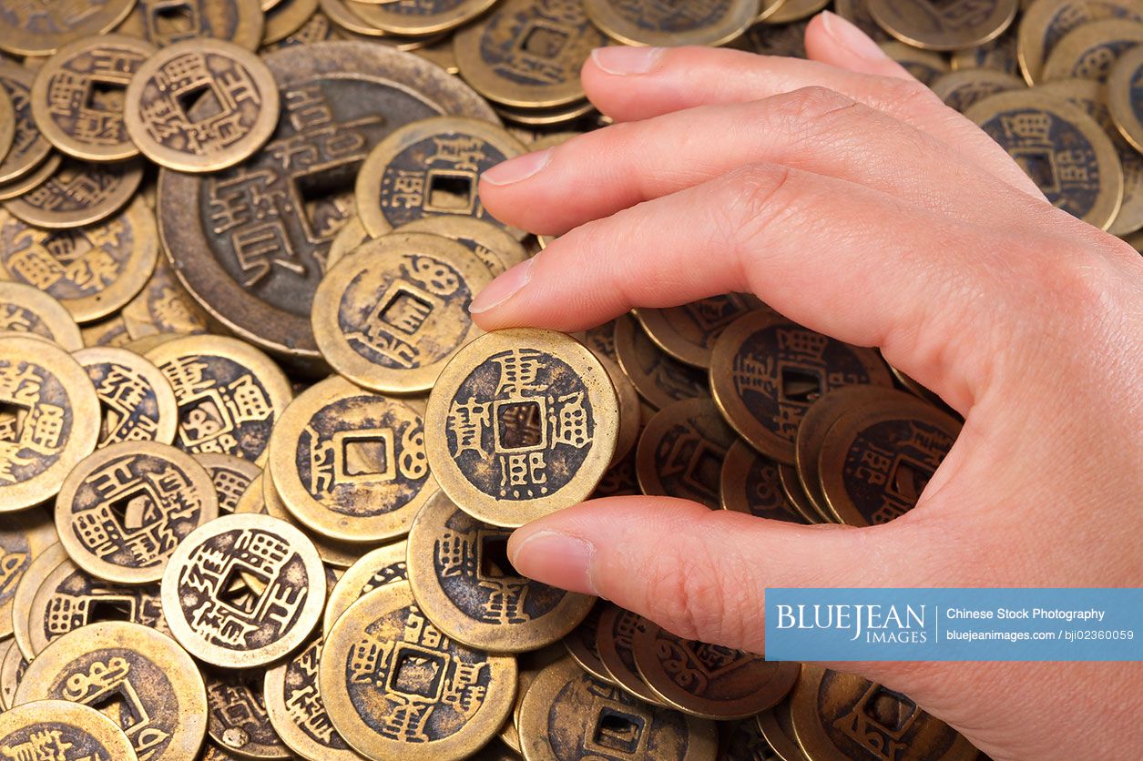 Hand holding traditional Chinese coin