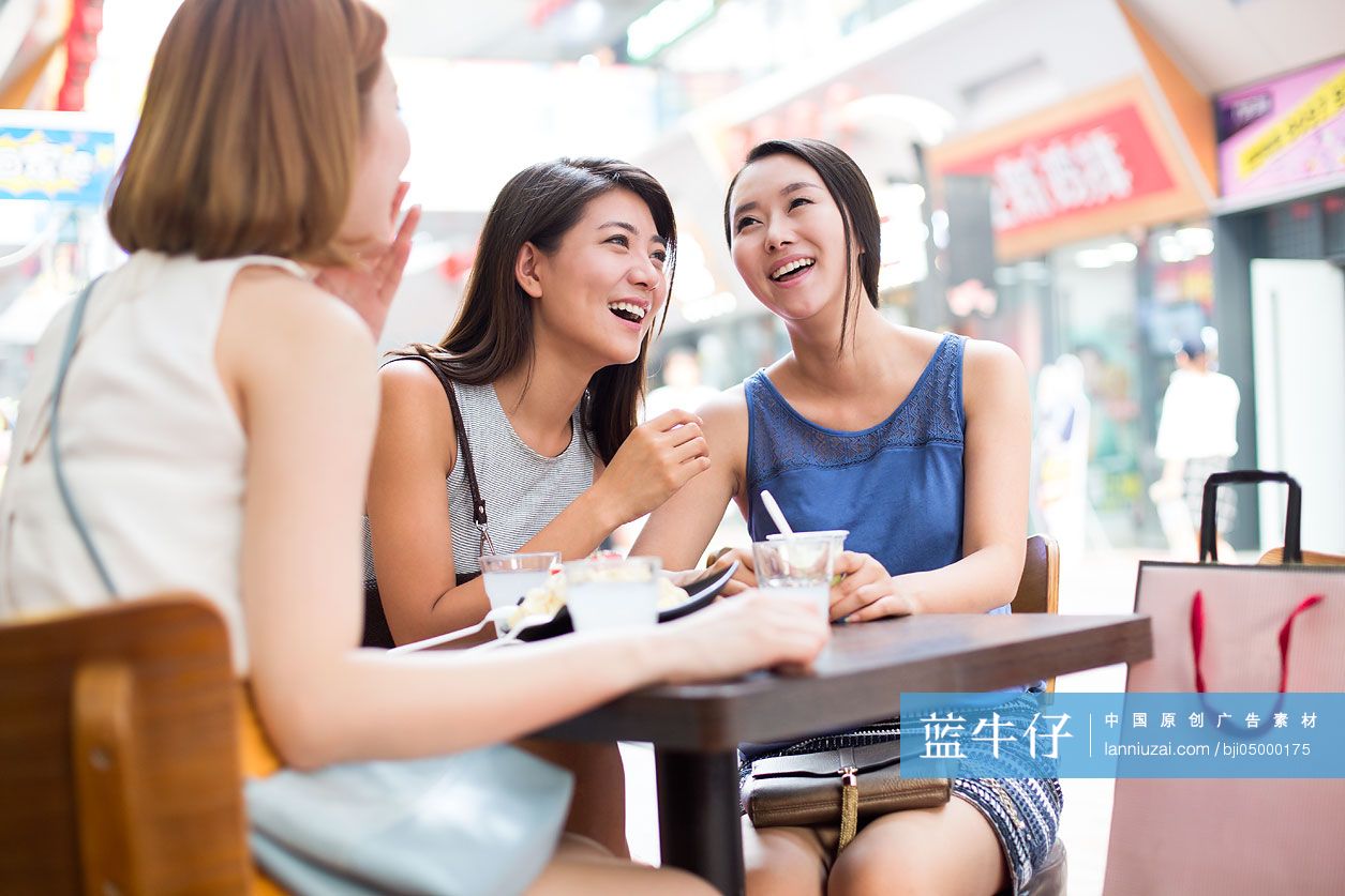 年轻闺蜜在露天咖啡馆聊天