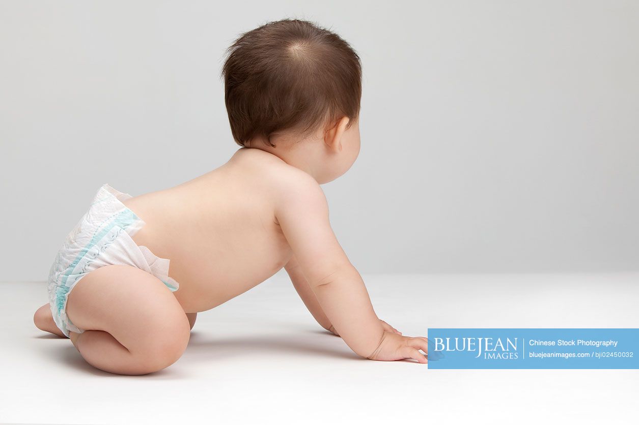 Studio shot of a cute Chinese baby boy looking away