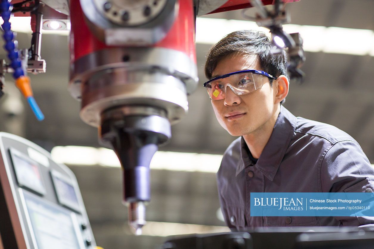 Young Chinese engineer working in the factory