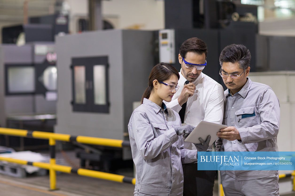 Businessman and engineers talking in the factory