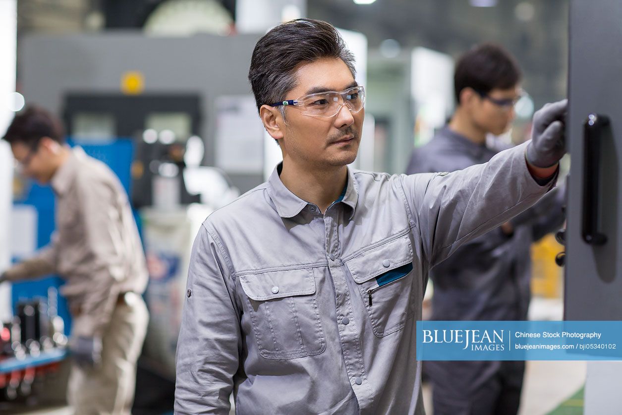 Confident Chinese engineers working in the factory
