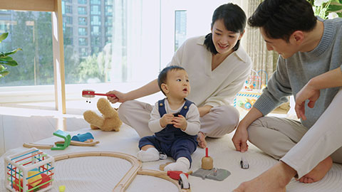 Young Chinese parents playing with their baby at home