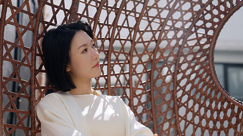 Happy young Chinese woman relaxing on hanging-chair,4K