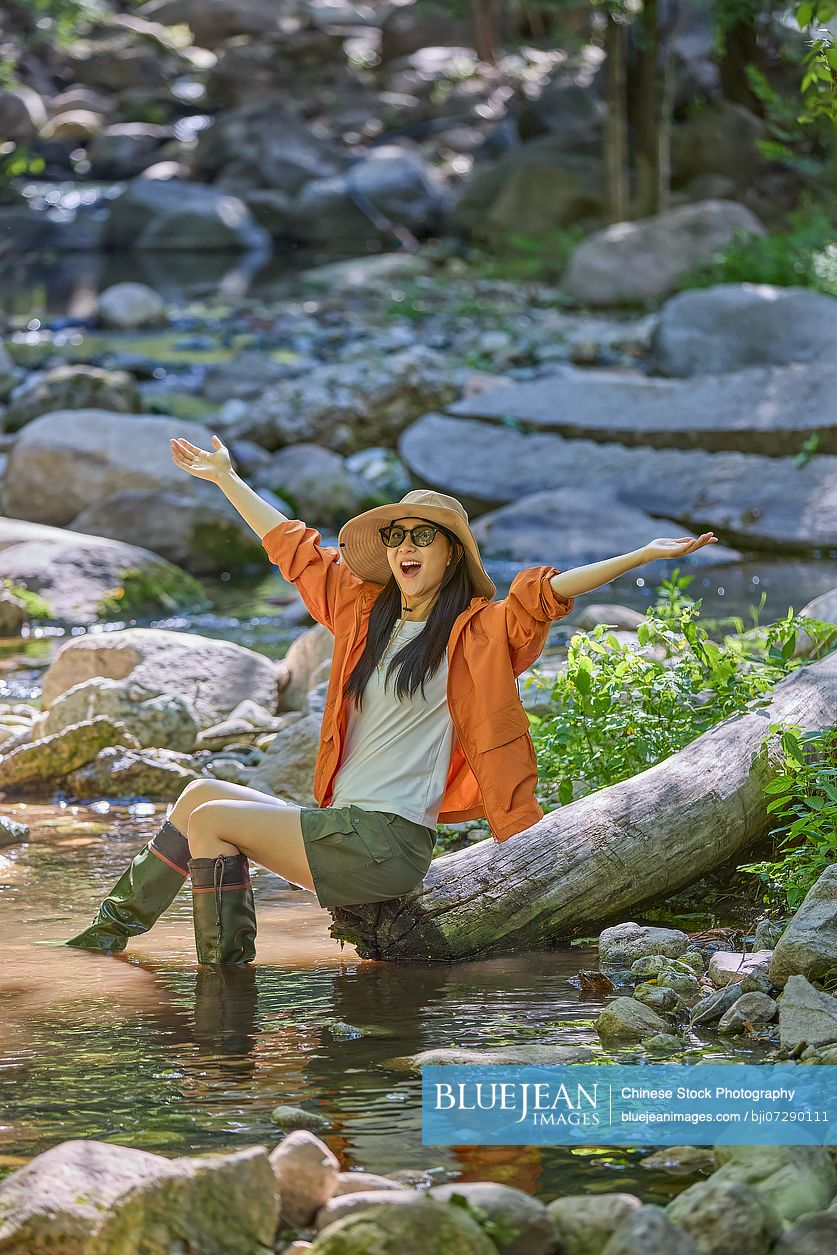 Young woman enjoying herself by the stream