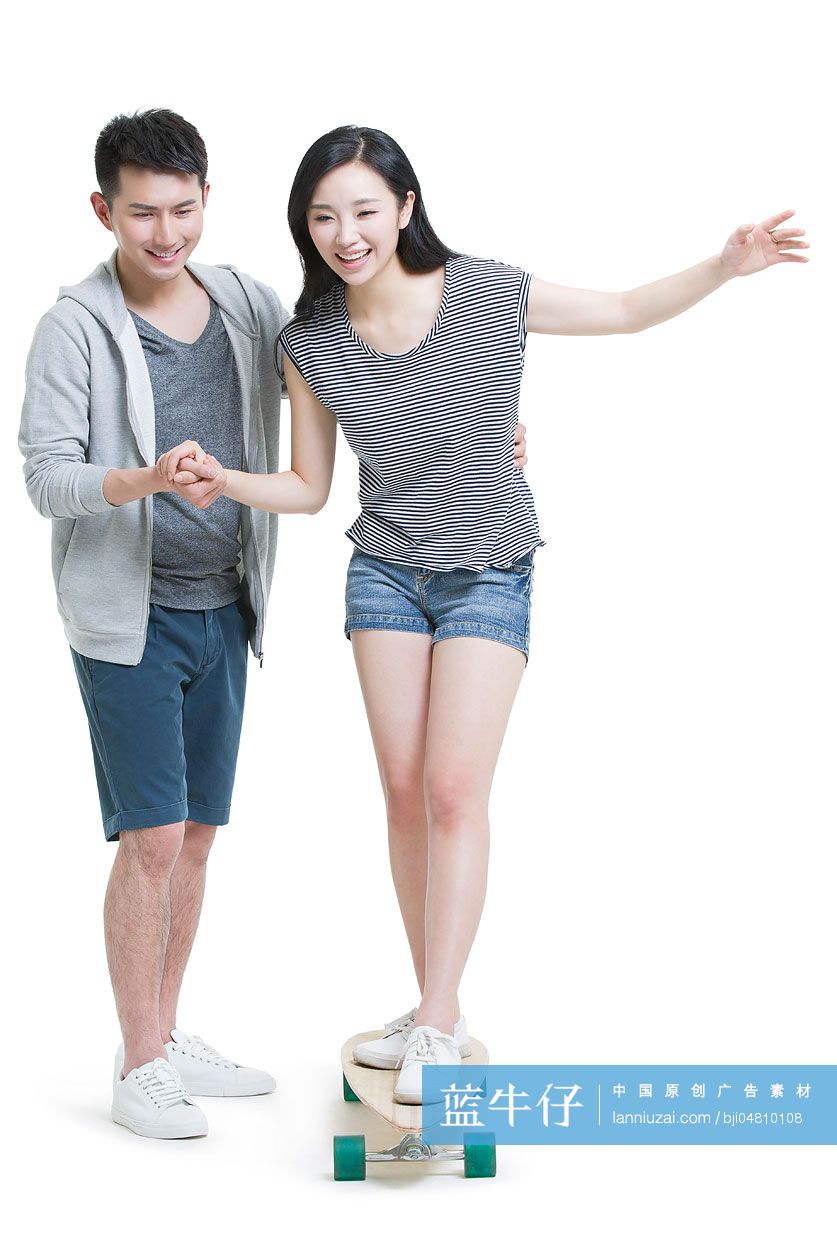 年轻男子教女朋友滑滑板