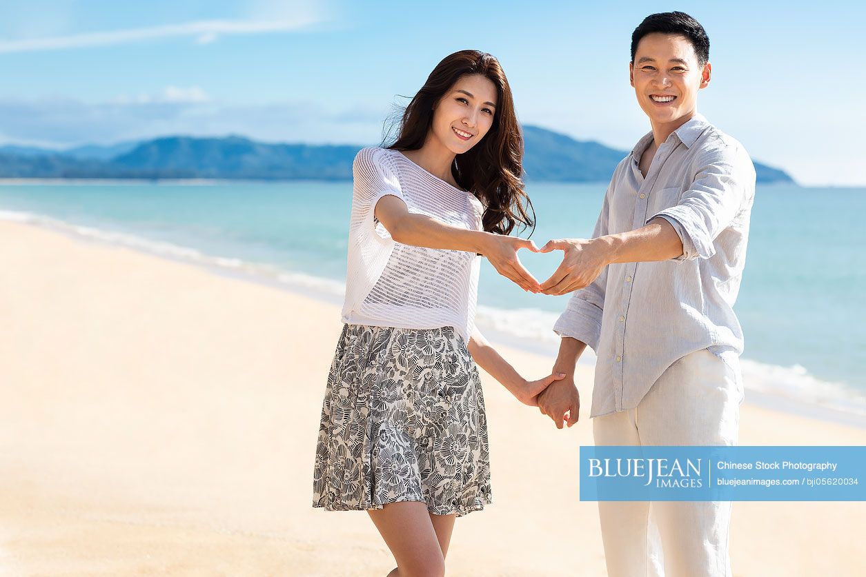 Romantic young Chinese couple on beach
